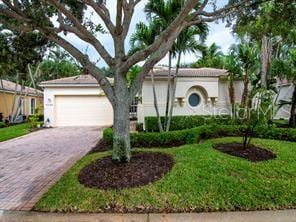 view of front facade featuring a garage, a front yard, and driveway