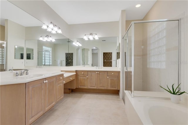 full bath featuring a stall shower, tile patterned flooring, a washtub, and vanity