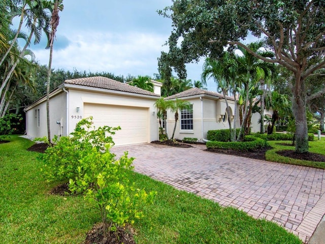 mediterranean / spanish-style home featuring a tile roof, a front lawn, decorative driveway, and stucco siding