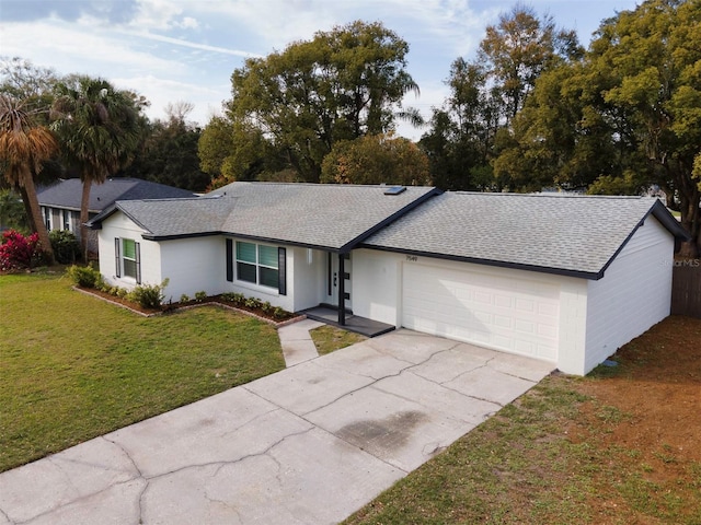 single story home featuring a garage, a front lawn, concrete driveway, and roof with shingles