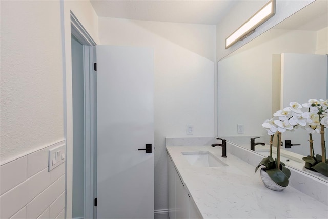 bathroom featuring tile walls and vanity