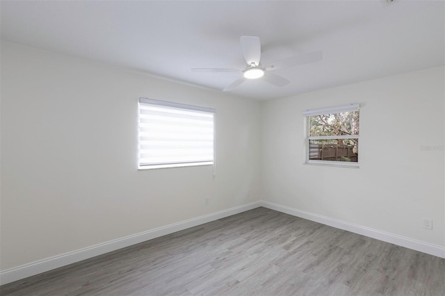 empty room featuring a ceiling fan, baseboards, and wood finished floors