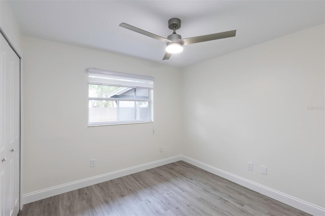 unfurnished bedroom with baseboards, a closet, and wood finished floors