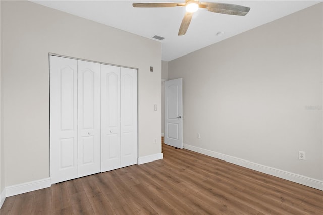 unfurnished bedroom featuring a closet, wood finished floors, visible vents, and baseboards