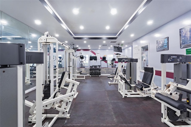 exercise room featuring a tray ceiling, visible vents, and recessed lighting