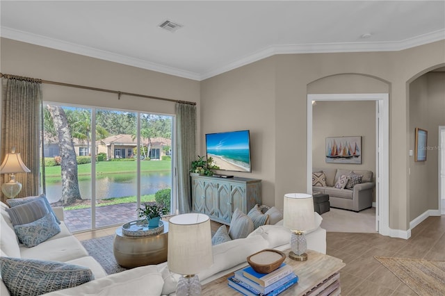 living area featuring baseboards, visible vents, arched walkways, and ornamental molding