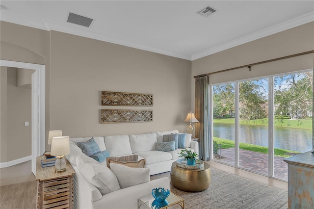 tiled living area with a water view, baseboards, visible vents, and ornamental molding