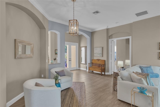 living area with baseboards, visible vents, and ornamental molding