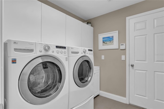 laundry area with washer and dryer, cabinet space, baseboards, and light tile patterned floors