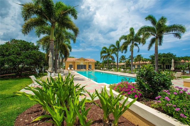 community pool featuring a lawn and a patio area