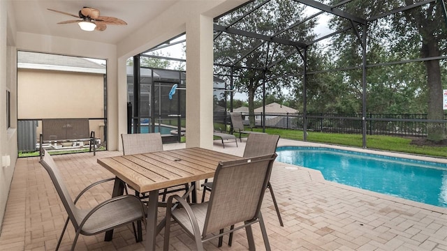 view of swimming pool with ceiling fan, a patio area, a lanai, and a fenced in pool