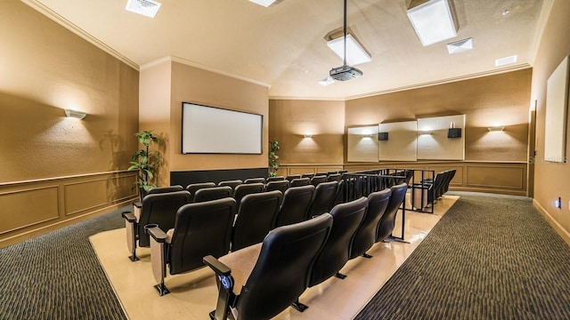 cinema room featuring visible vents, a decorative wall, and crown molding