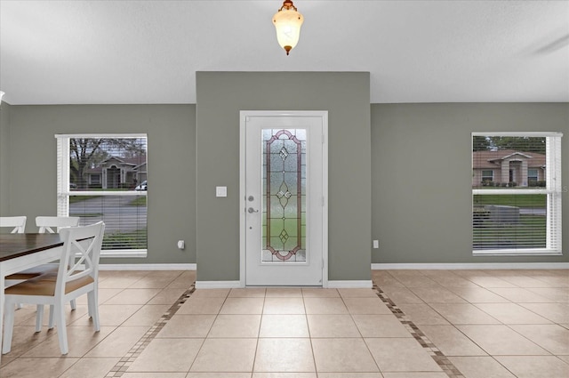 entrance foyer with plenty of natural light, baseboards, and light tile patterned floors