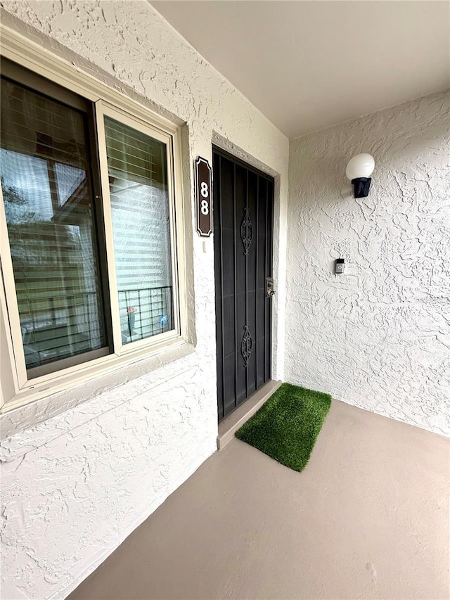 entrance to property featuring stucco siding