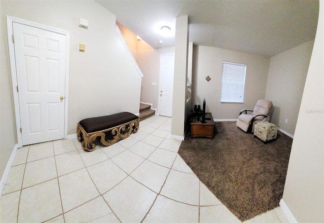 living area featuring light tile patterned floors, stairway, and baseboards