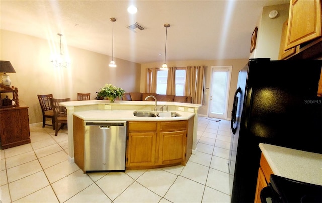 kitchen with light tile patterned floors, a sink, light countertops, stainless steel dishwasher, and freestanding refrigerator