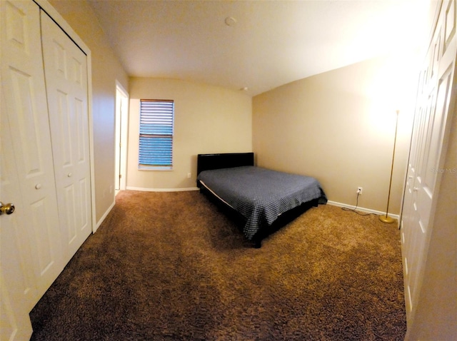 carpeted bedroom featuring a closet and baseboards