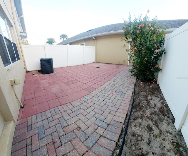 view of patio with a fenced backyard and central air condition unit