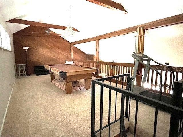 recreation room with carpet floors, pool table, and wooden walls