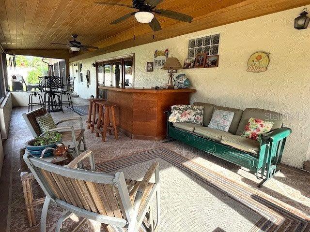 exterior space with outdoor lounge area, ceiling fan, and outdoor dry bar