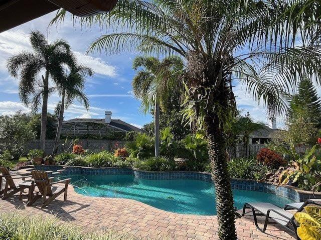 outdoor pool featuring a patio area and fence