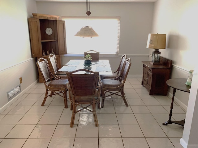 dining room featuring light tile patterned floors, baseboards, and visible vents