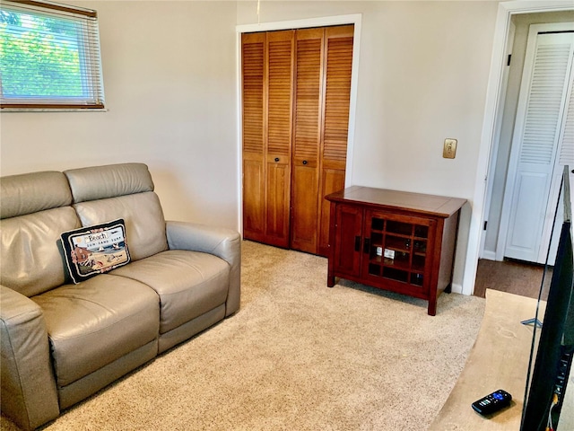 carpeted living area featuring baseboards