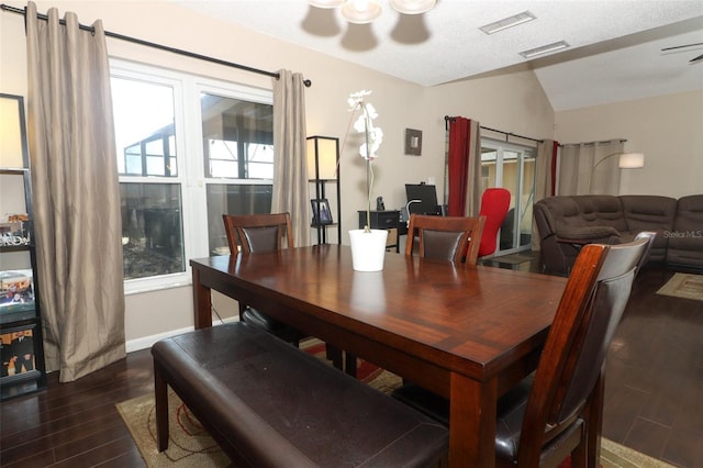 dining room with lofted ceiling, dark wood finished floors, visible vents, and baseboards