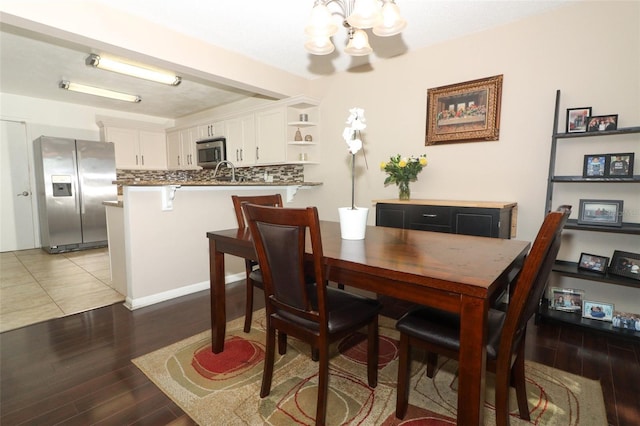 dining space featuring light wood-style flooring and a notable chandelier