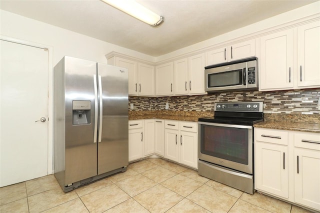 kitchen featuring light tile patterned floors, stainless steel appliances, tasteful backsplash, and dark stone countertops