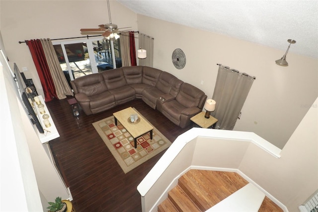 living room with vaulted ceiling, a textured ceiling, and wood finished floors