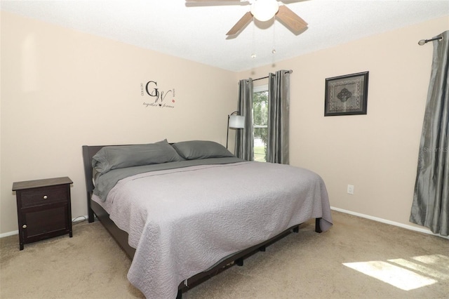 bedroom with light carpet, a ceiling fan, and baseboards