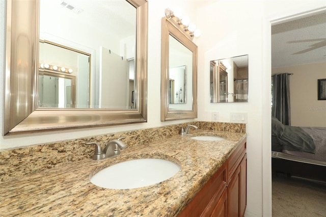 bathroom featuring ensuite bathroom, double vanity, a sink, and visible vents