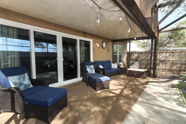 view of patio / terrace featuring glass enclosure, fence, and outdoor lounge area