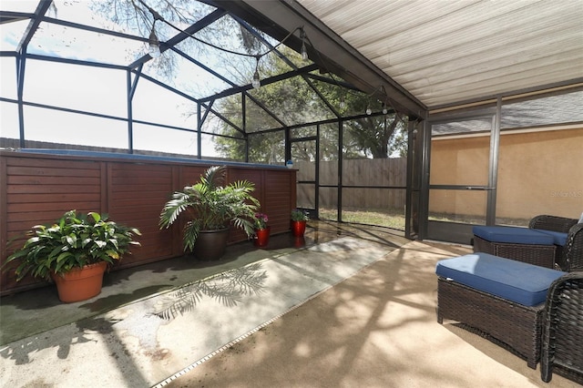 view of patio featuring a lanai and fence