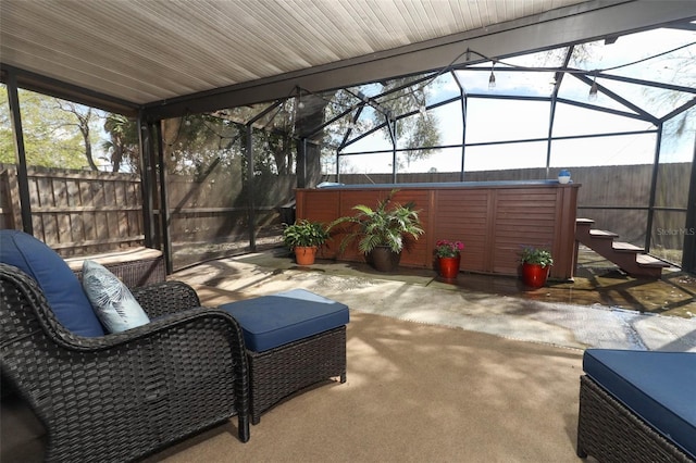 exterior space featuring glass enclosure, fence, and a jacuzzi