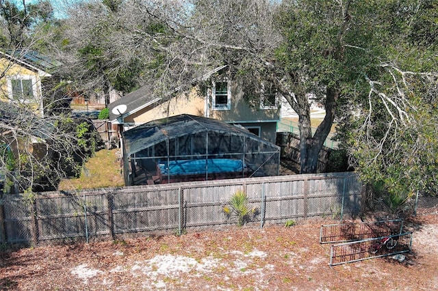 view of yard featuring glass enclosure and a fenced backyard