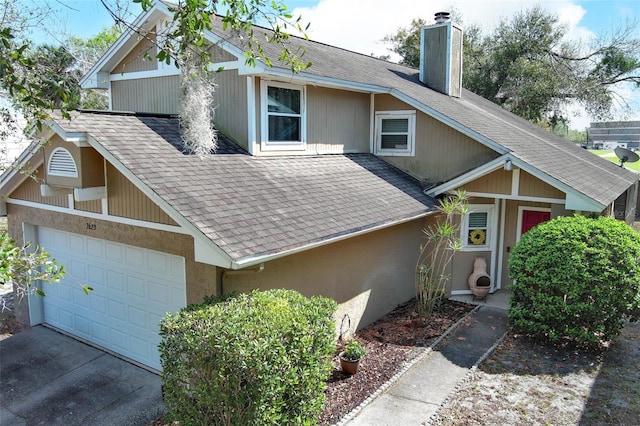 view of front of property featuring a shingled roof, driveway, and a chimney