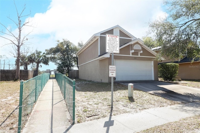 view of front of property with concrete driveway, fence, and stucco siding