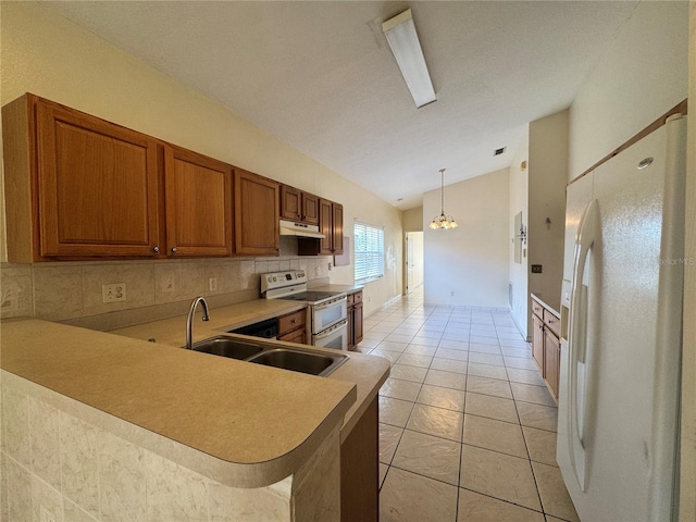 kitchen featuring white refrigerator with ice dispenser, brown cabinets, under cabinet range hood, double oven range, and a sink