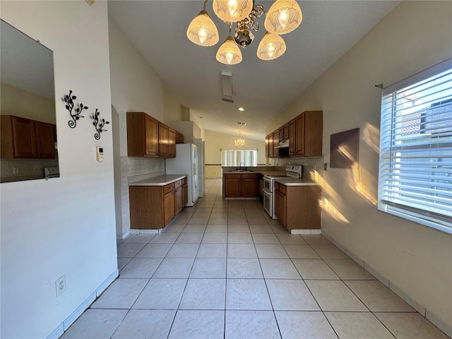 kitchen featuring a notable chandelier, a sink, freestanding refrigerator, and double oven range