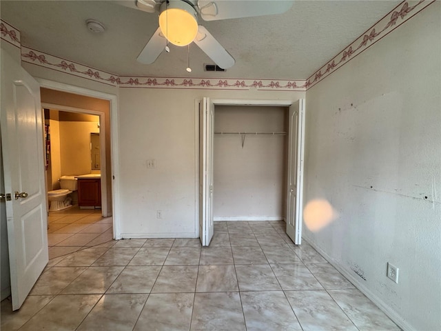 unfurnished bedroom with visible vents, ceiling fan, a textured ceiling, a closet, and light tile patterned flooring