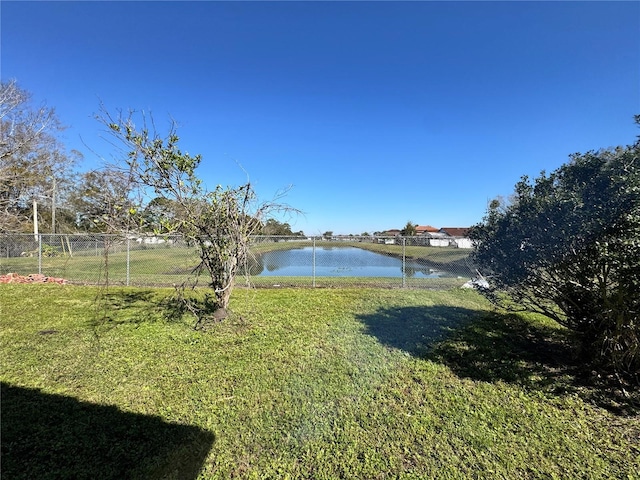 view of yard with a water view and fence