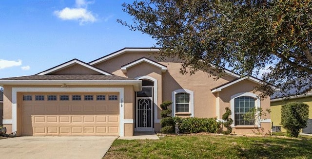 ranch-style house with an attached garage, driveway, a front lawn, and stucco siding