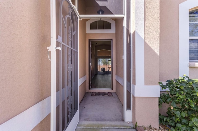 doorway to property featuring visible vents and stucco siding