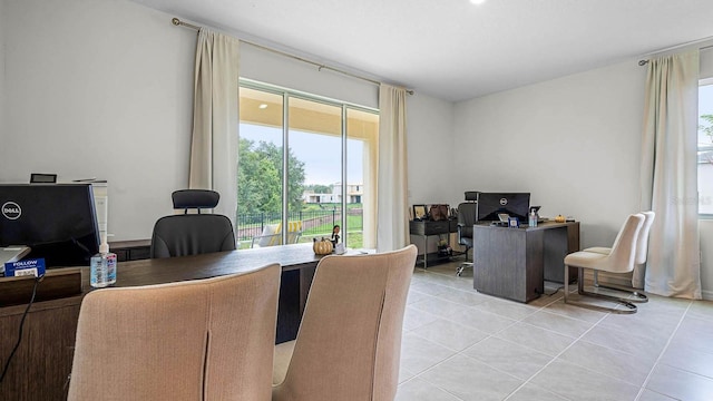 office area with light tile patterned floors and a healthy amount of sunlight