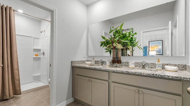 bathroom featuring a shower stall, double vanity, a sink, and tile patterned floors