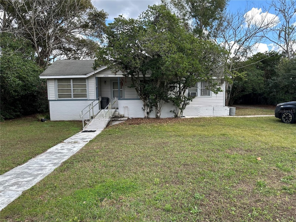 view of front facade with brick siding and a front yard