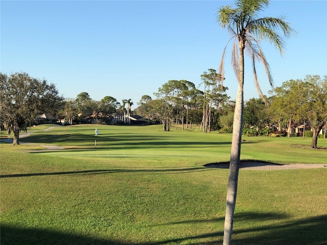 view of property's community with a yard and golf course view