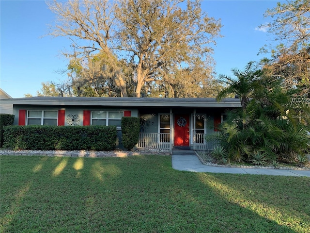 217 Wilmer Ave, Orlando, FL 32811 - ranch-style house featuring covered porch and a front yard